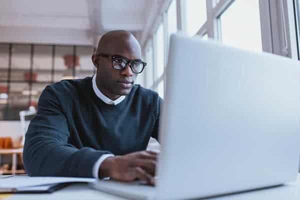 freelancer working on laptop protected by freelance indemnity insurance