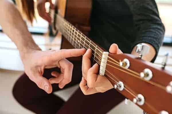 Ways to beat the January blues - lady taking up a new hobby and learning to play the guitar