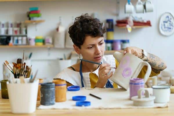 A side hustler working in a pottery workshop. a side hustler working in a pottery workshop.