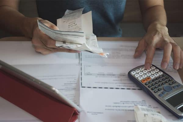 A small business owner using a calculator to work out expenses.