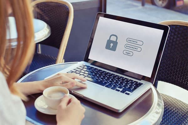 An image of a padlock and a login system is showing on a woman’s laptop screen.