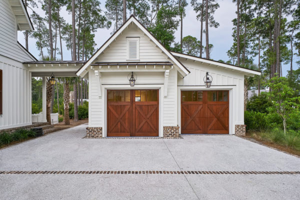 use traditional barn doors to complete a large country-styled detached garage with breezeway