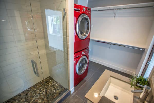 metallic red washer and dryer in this modern bathroom and laundry combo with clothes hangers