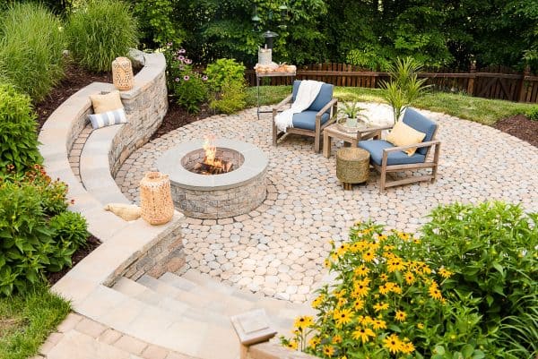 build a retaining wall fire pit with seating complete with rattan accents to evoke a cozy vibe