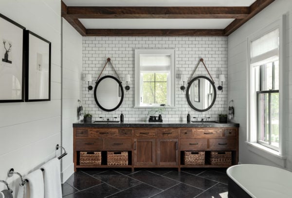 this farmhouse bathroom has a modern subway tile with black grout backsplash and rustic wood elements