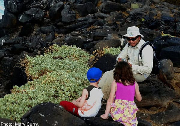 A guide talks to two young children on one of the galapagos islands