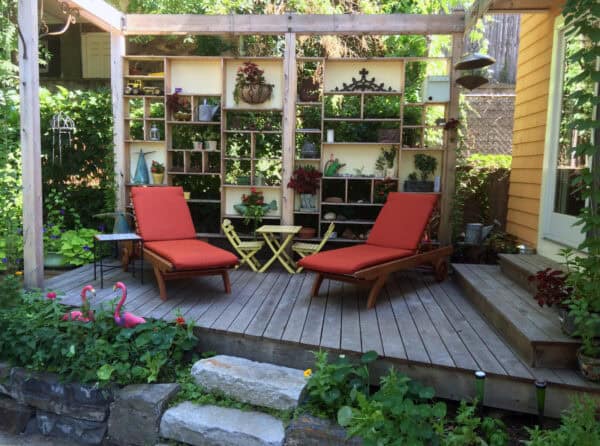 this small backyard deck idea uses salvaged wood and stones for a unique and eclectic floating effect