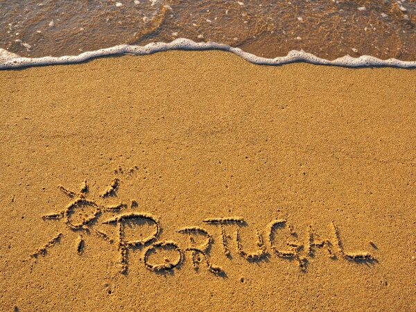 Portugal written in the sand on the beach.