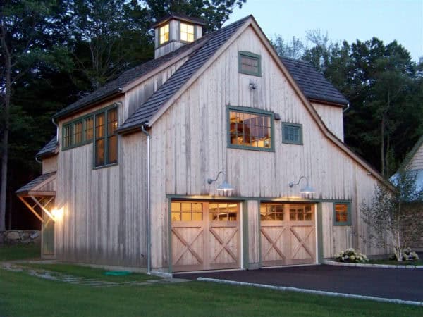 mountain-style cabin looks gorgeous with rustic cedar garage doors and pine siding