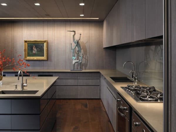 try a contemporary kitchen featuring grey-stained cabinets, grey wall panels, and lagos blue countertops