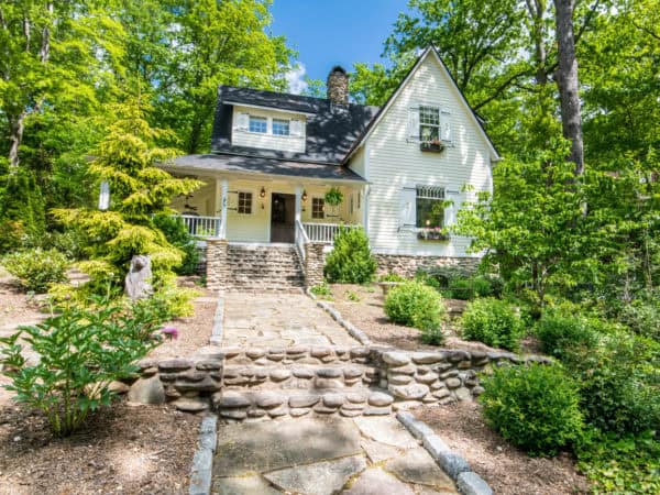 a quintessentially country front yard featuring stone retaining wall and victorian style exterior