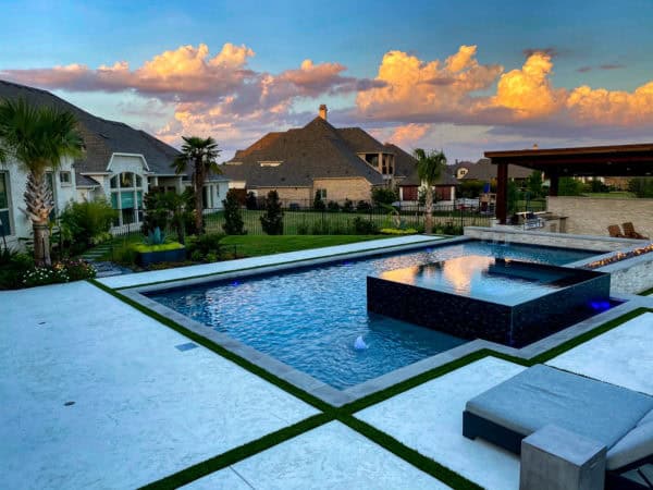 try a modern pool deck using stamped concrete, tropical plantings, and a contemporary cabana