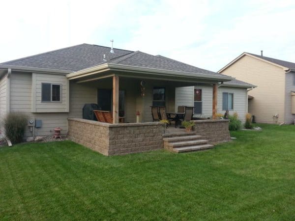 build a classic raised patio against the house complete with a roof extension and cozy seating