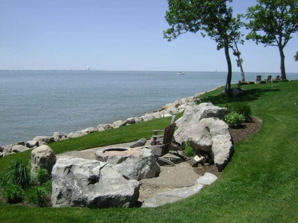 a hillside retaining wall fire pit that overlooks the transcendental ocean creates a cozy nook in nature