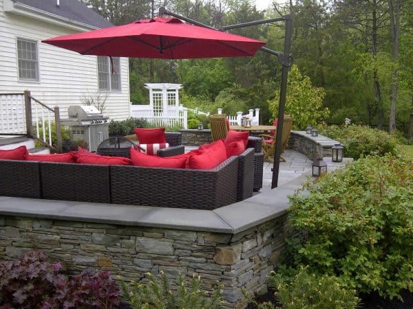 use a bright red upholstery idea that pops against bluestone retaining wall cap and colonial stone