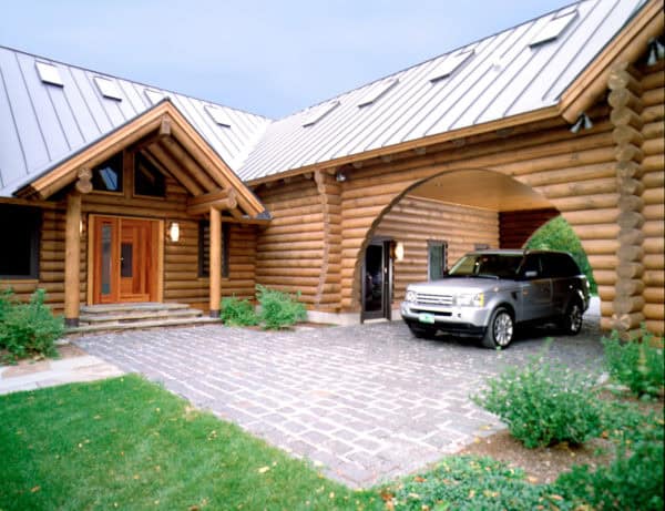 charming wooden log carport with circular silhouette in front of this cabin-style house