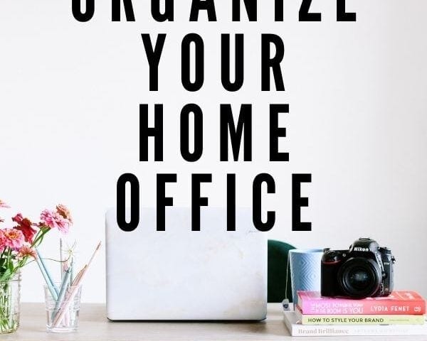 deskwith laptop books office supplies camera and colorful flowers