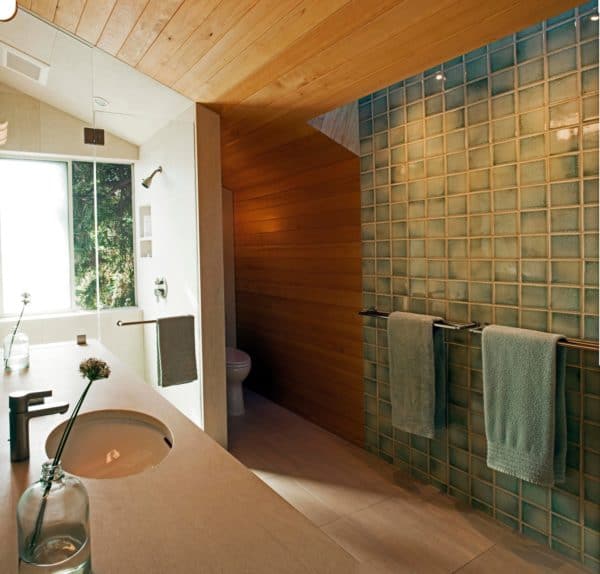 maximize a slanted bathroom with alcove shower by mixing green and brown walls