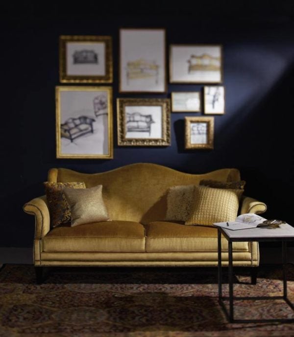 create a stunning formal living room featuring navy blue walls, gold frames, and gold couch