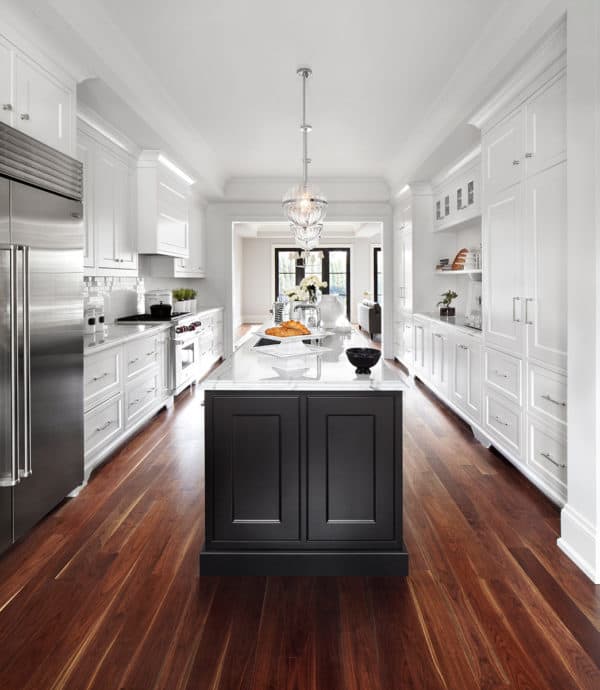 use brown wood flooring to sweeten a large contemporary kitchen with white walls and cabinetry