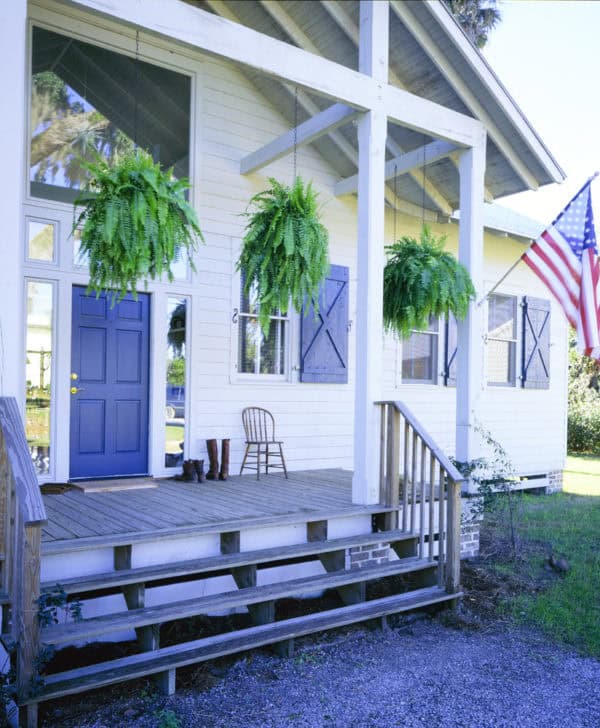 create a lovely porch with blue barn door window shutters to complement the classic front door design