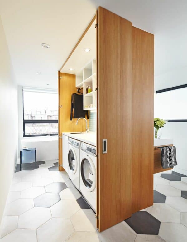 create a mini laundry room in your bathroom with a wood toned false wall and shelves