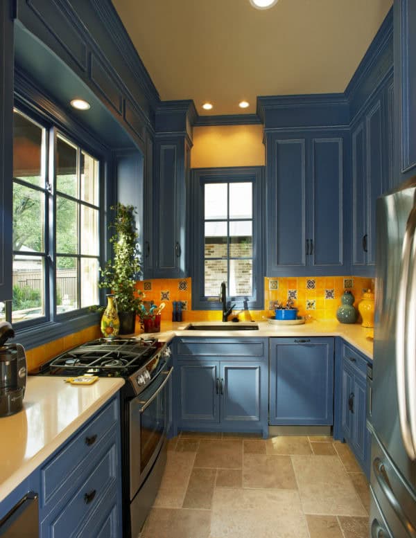 classic u-shaped kitchen with prussian blue cabinets and fire yellow ceramic backsplash