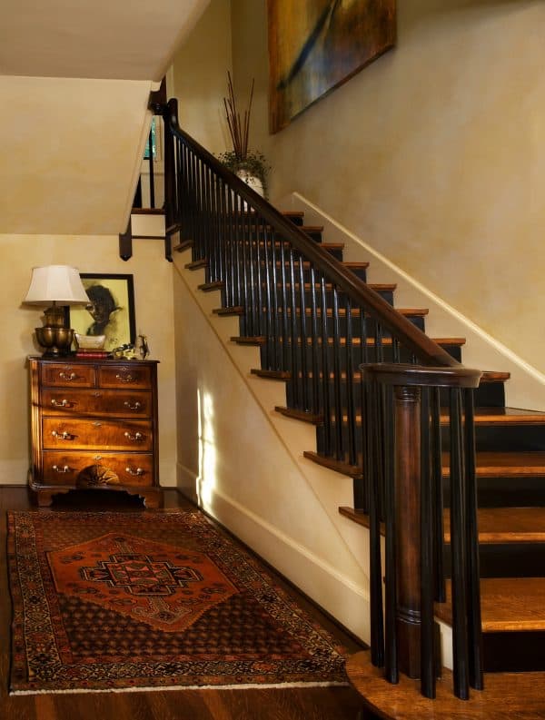 revive the timeless tudor style in this indoor dark walnut l-shaped wood stair railing design