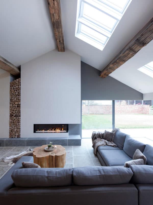 barn lounge combines white walls and natural wood beams with comfy l-shaped gray couch