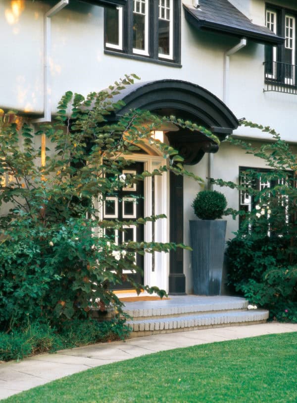 try a curved roof over door entry in this gorgeous black and white home for a timeless look