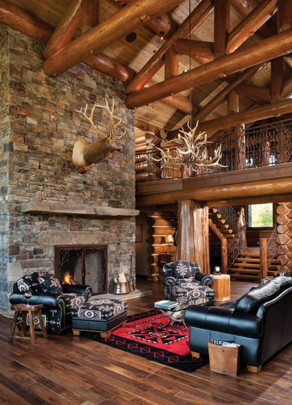 use floor-to-ceiling moss rock fireplaces in a rustic handcrafted log cabin living room