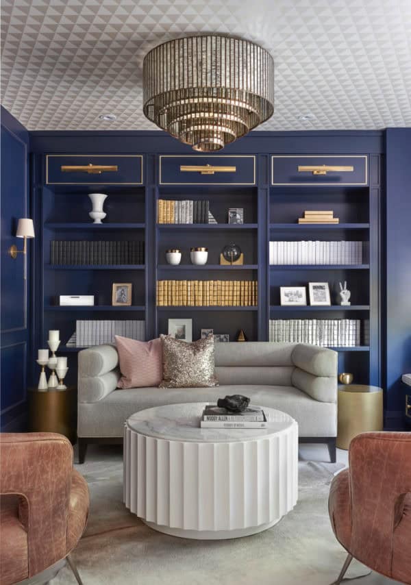 high-class living room with royal blue built-in bookcase and gold accents