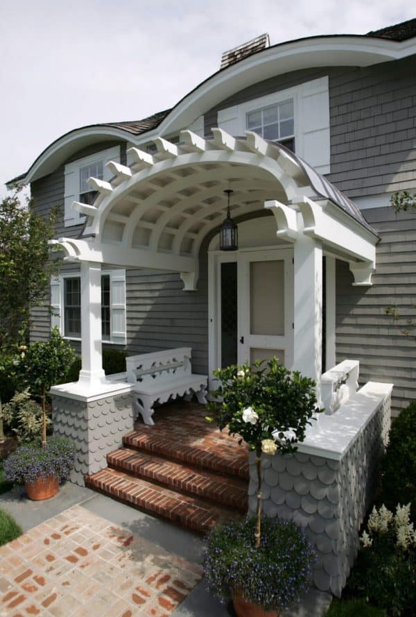 victorian barn-inspired entryway with a white front door and swedish carved benches