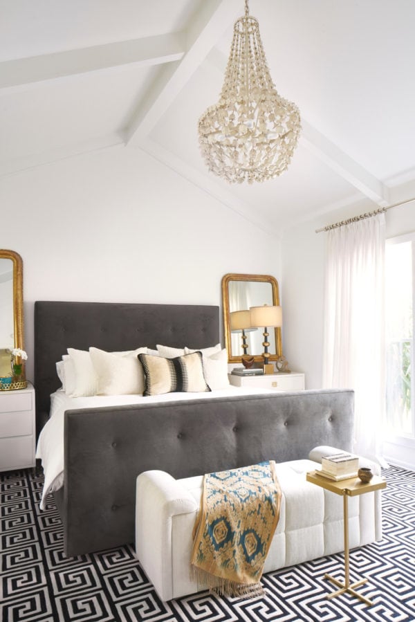 an eclectic sanctuary of white bedroom highlighted by gold throw, lamps, and mirrors