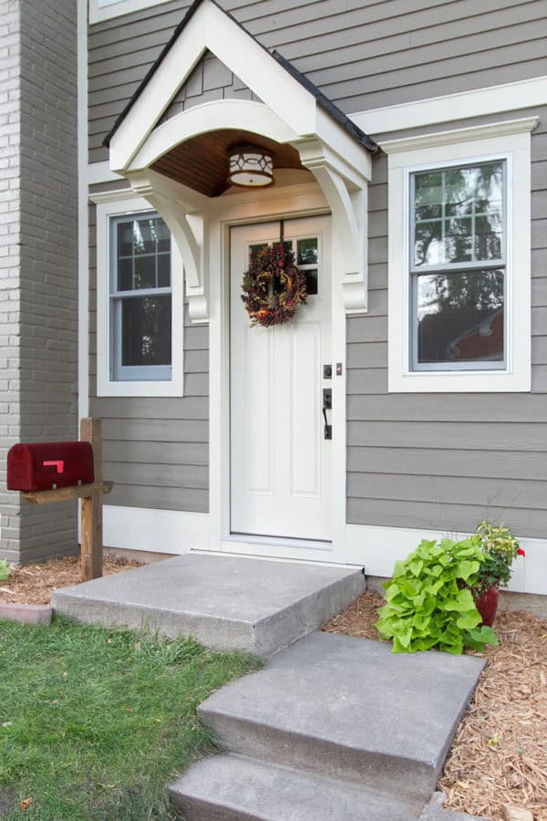 raw concrete front steps to match a grey farmhouse design exterior