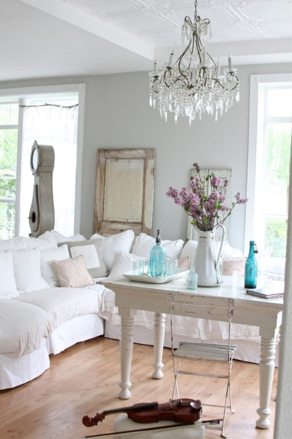 hang a crystal chandelier for some sophistication in this modern living room with gray walls and white fabric couch