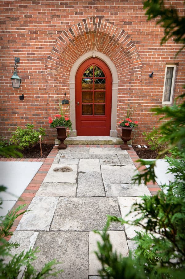 a charming arc red door with large glass panes and brick wall exterior for a historical ambiance