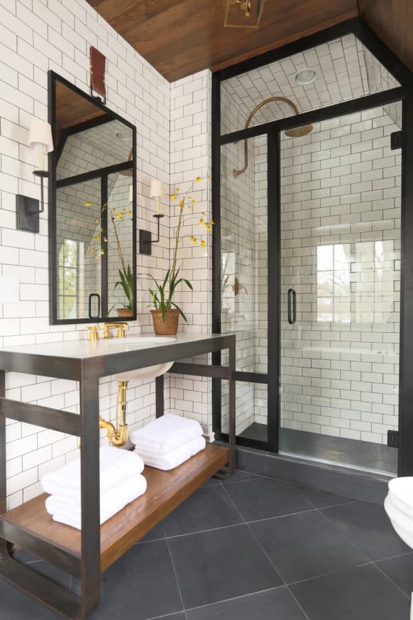 use black accents and medium tone wood to complement subway tile with black grout walls