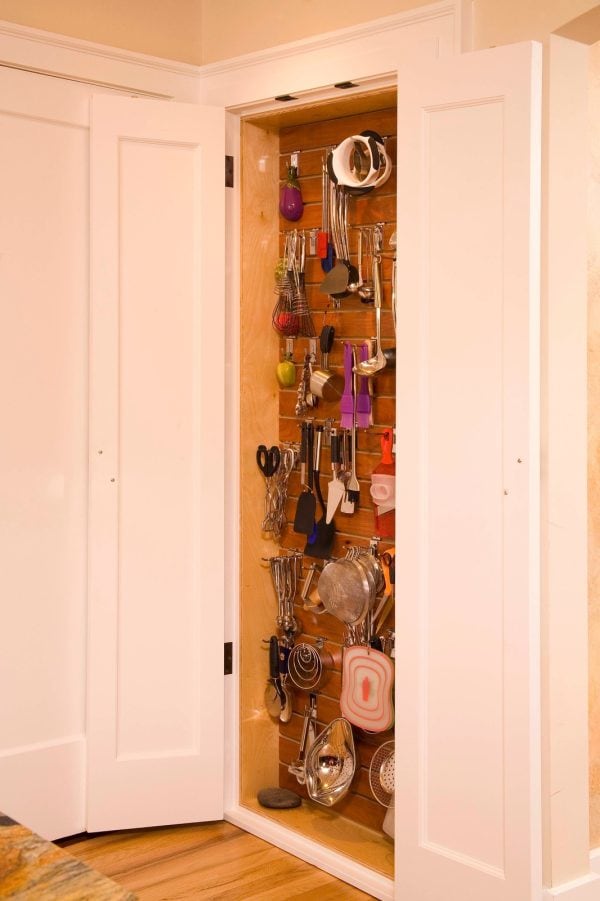 this small but effective recessed wall cabinet between kitchen studs can store cooking tools