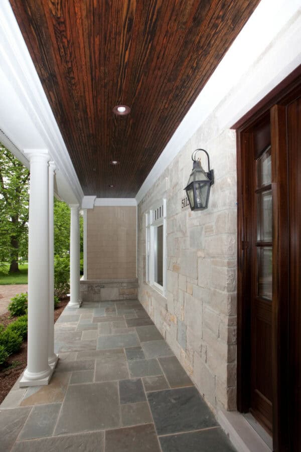 build a classic and attractive front porch featuring slate tiles, stone walls, and deep wood surfaces