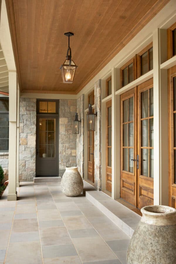 this rustic country estate features indiana limestone front porch tile and dark bronze french doors