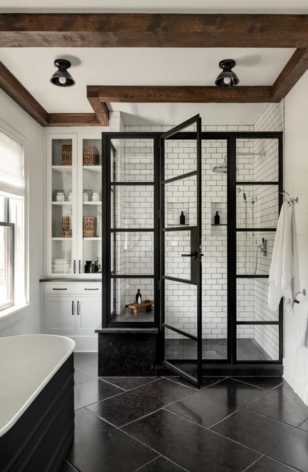 introduce wooden ceiling beams to enhance a cottage bathroom featuring subway tile with black grout walls