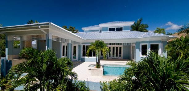 a beach-style exterior with light blue stucco and white trim