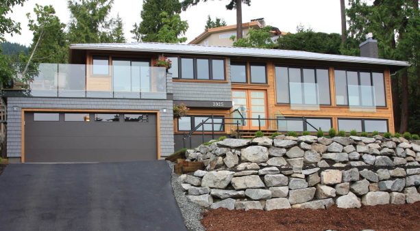 pretty large rocks perfectly make a tall rip rap retaining wall in front of a house on a highland