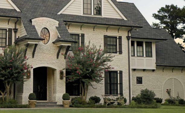 mid-sized white brick house with clad windows plus shutters