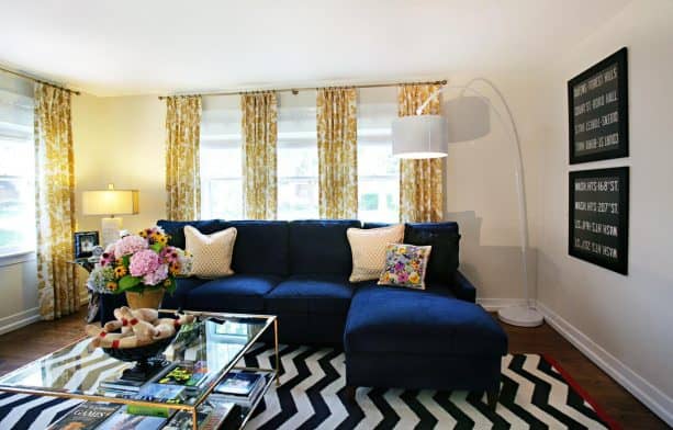 living room with navy blue sectional couch and yellow drapes