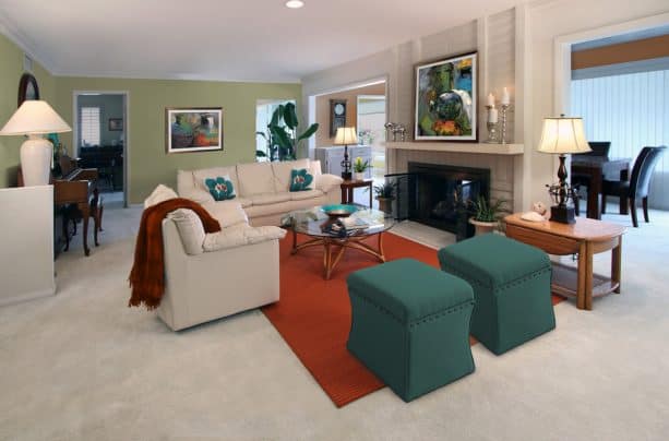 a living room with teal ottomans and rust rug