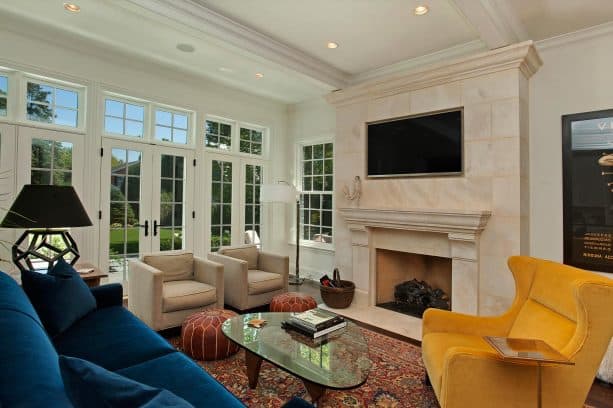 a living room with teal couch and beige chairs