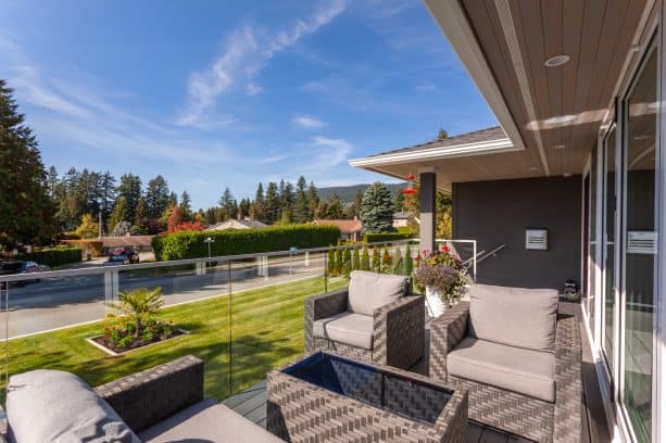 deck-style front porch with clear glass railing