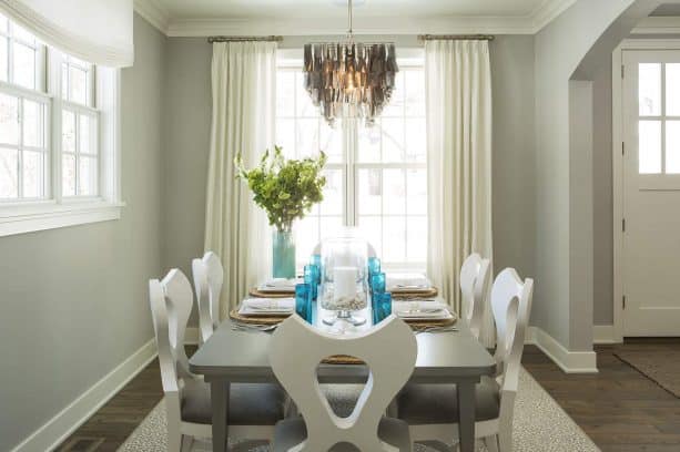 beach style dining room with grey wall and reclaimed wood floor